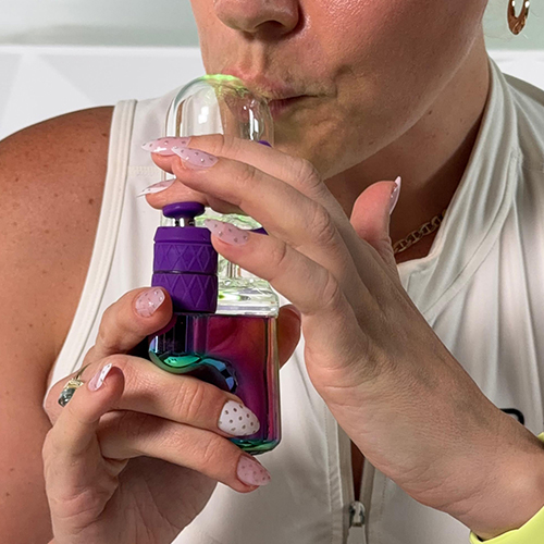 Femme qui inhale avec le Bomb Aerix Erig et son embout en verre