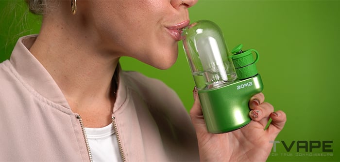 Une femme inhale à partir du Bomb Magloud E Rig.