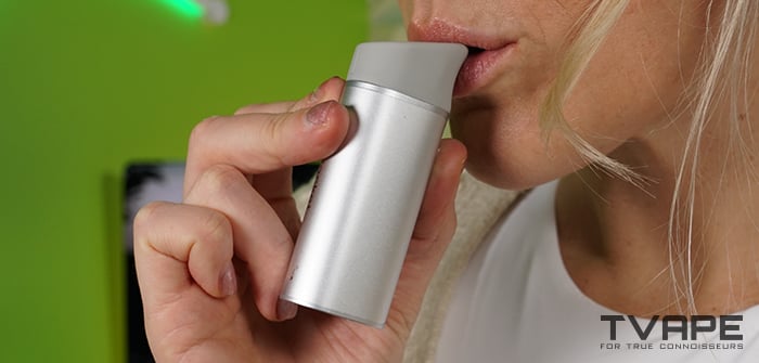 Une femme tire une bouffée sur le stylo dab Yocan Black Pocket.